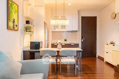 Modern open-plan living and dining area with stylish decor and wooden flooring.