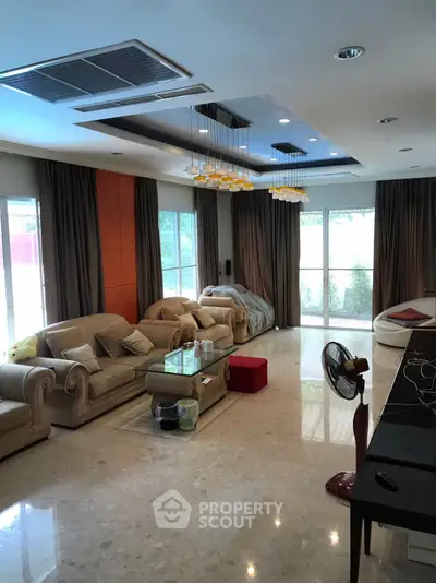 Spacious living room with elegant sofas and modern lighting, perfect for relaxation and entertainment.