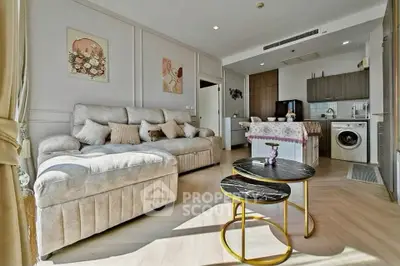 Stylish living room with modern kitchen and cozy seating area in open layout apartment.
