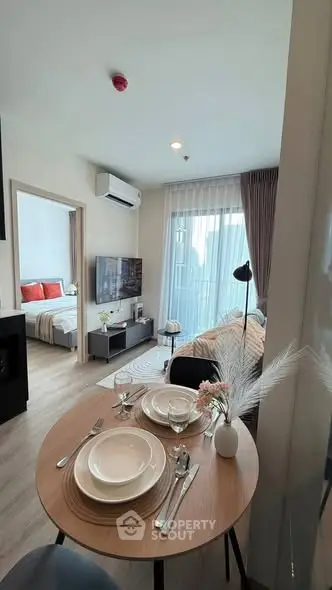 Modern open-plan living room with dining area and bedroom view