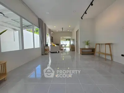 Spacious modern living room with sleek tile flooring and abundant natural light.