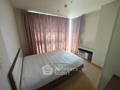 Spacious bedroom with large window and elegant curtains in modern apartment