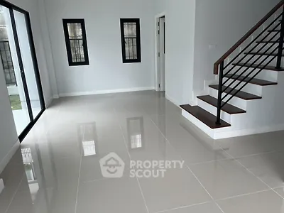 Spacious modern living room with sleek staircase and large windows