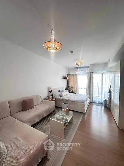 Spacious bedroom with cozy seating area and modern lighting