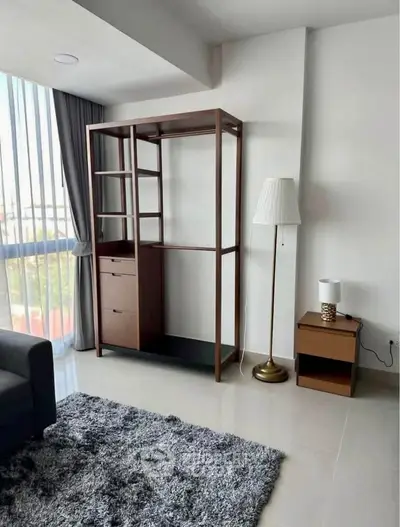 Modern living room with stylish furniture and large window offering natural light.