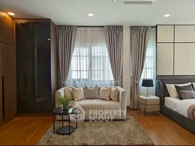 Elegant modern living room with cozy sofa, stylish decor, and natural light from large windows.