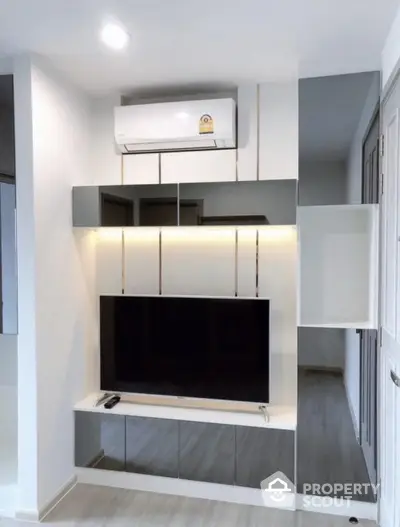 Modern living room with sleek TV setup and air conditioning, perfect for comfortable living.