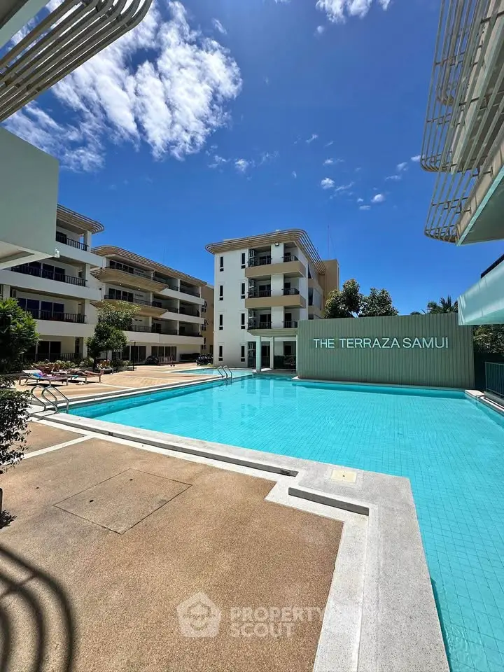 Luxurious poolside view at The Terraza Samui with modern architecture and clear blue skies.