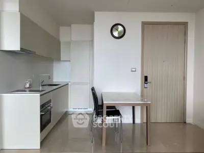 Modern kitchen with sleek cabinetry and dining area in contemporary apartment
