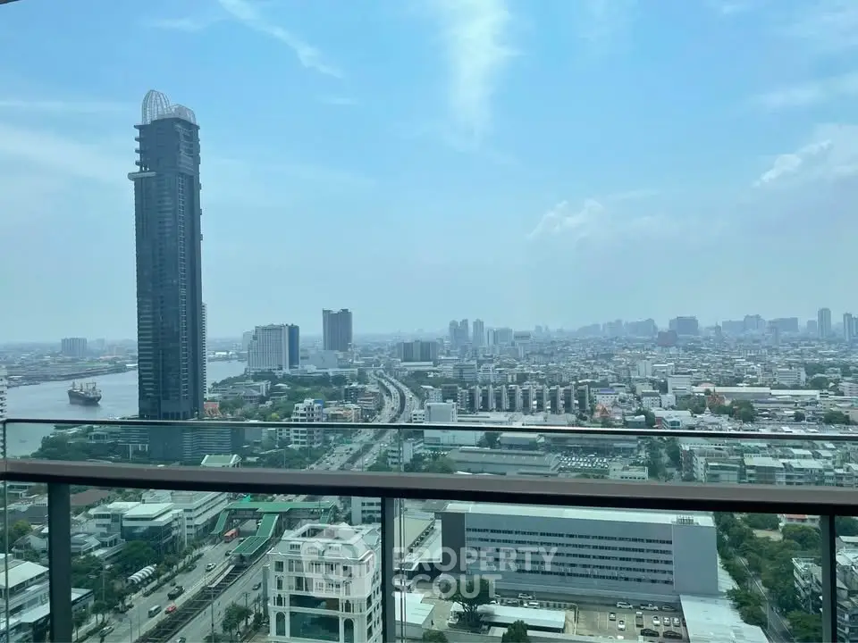 Stunning cityscape view from high-rise balcony overlooking river and skyline.