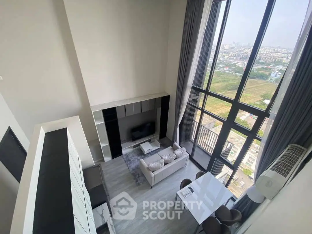 Stunning loft-style living room with floor-to-ceiling windows and panoramic city views.