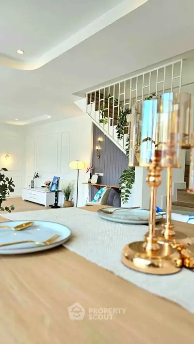 Elegant modern living room with stylish decor and open layout, featuring gold accents and natural light.