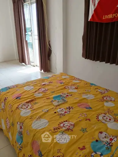 Cozy bedroom with bright decor and natural light from large window.