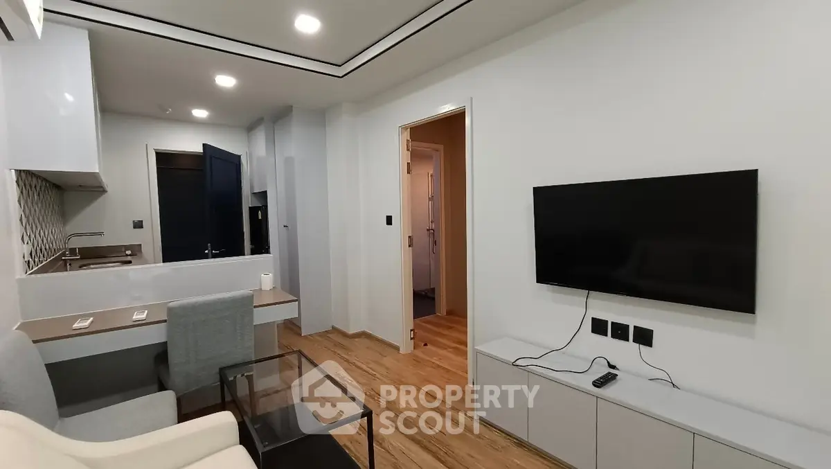 Modern living room with sleek TV setup and open kitchen layout