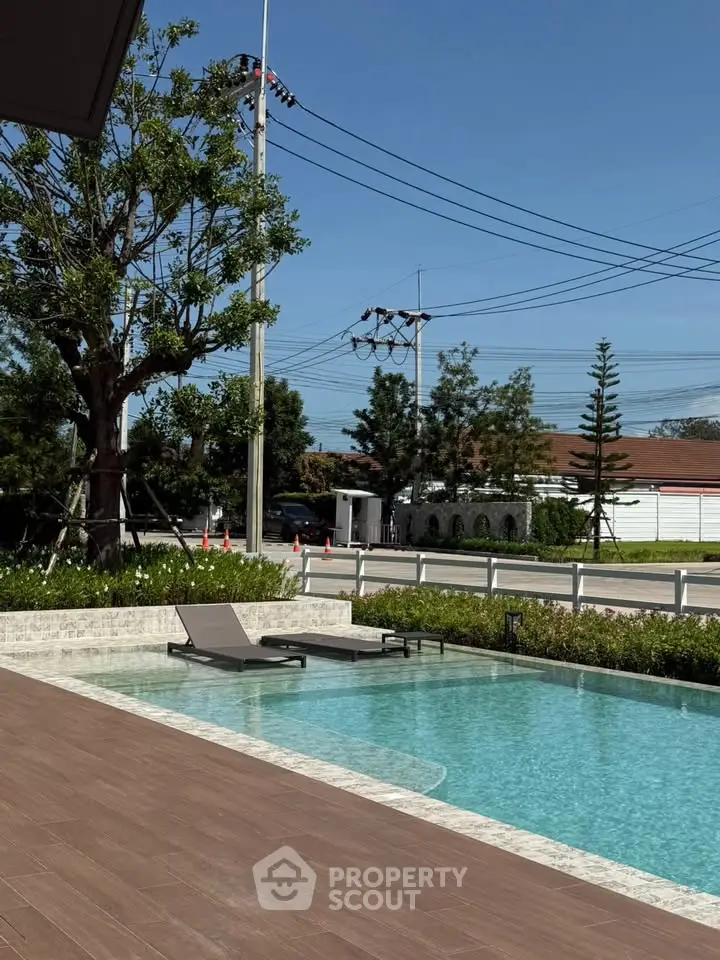 Luxurious outdoor pool area with sun loungers and lush greenery, perfect for relaxation and leisure.