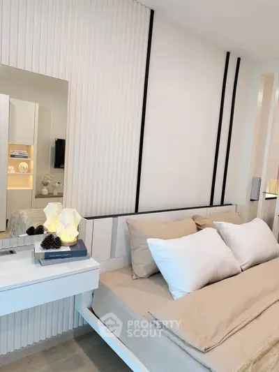 Modern bedroom with stylish decor and cozy bedding in a contemporary apartment.