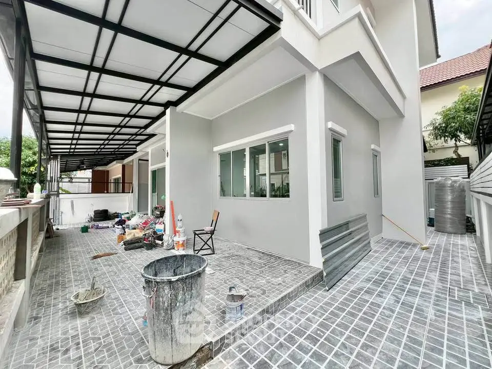 Modern house exterior with spacious tiled patio and covered area, ideal for outdoor activities.