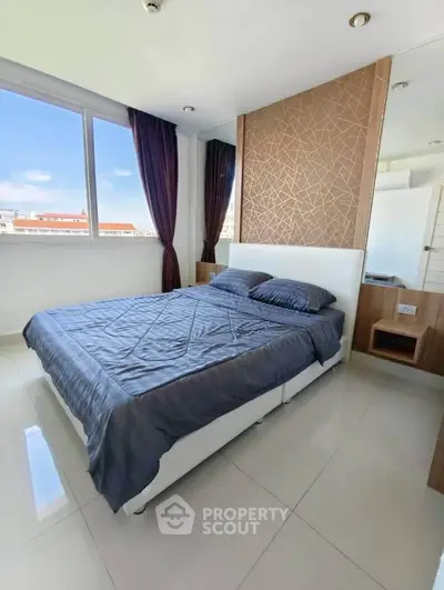 Modern bedroom with large window and stylish decor in a high-rise apartment.