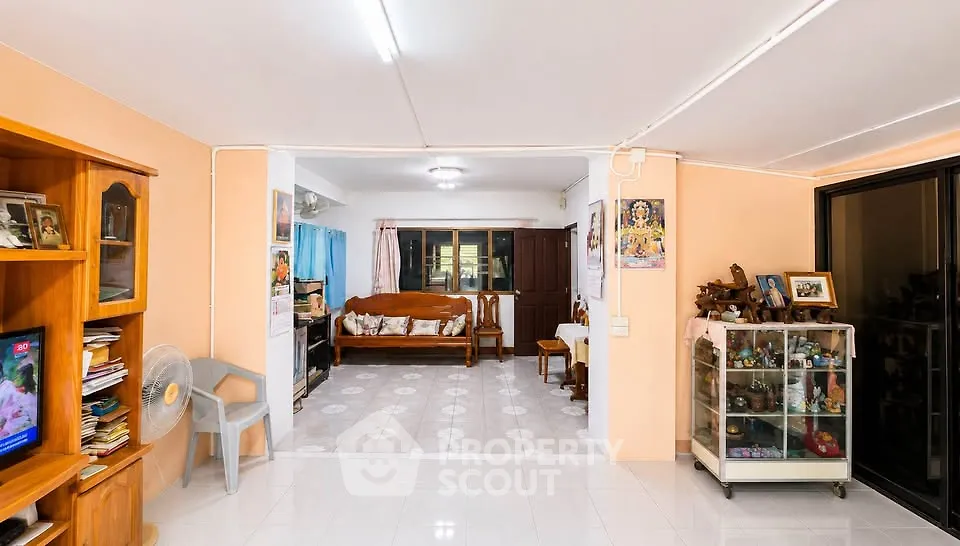 Spacious living room with cozy seating and decorative shelves in a well-lit home.