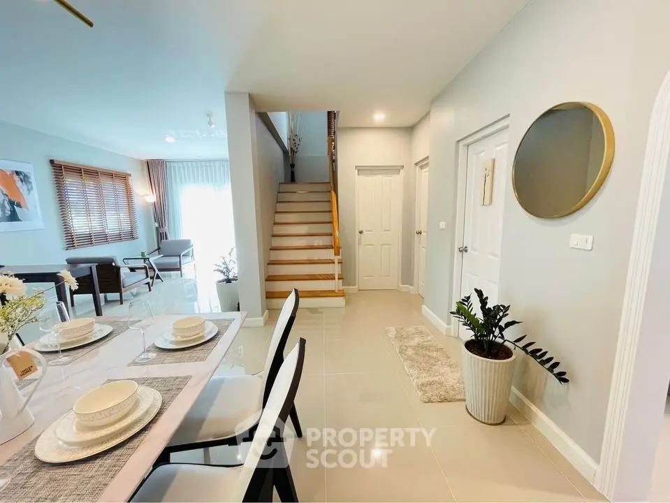 Modern dining area with elegant table setting and view of staircase in stylish home