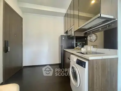 Modern kitchen with sleek appliances and washing machine in compact layout