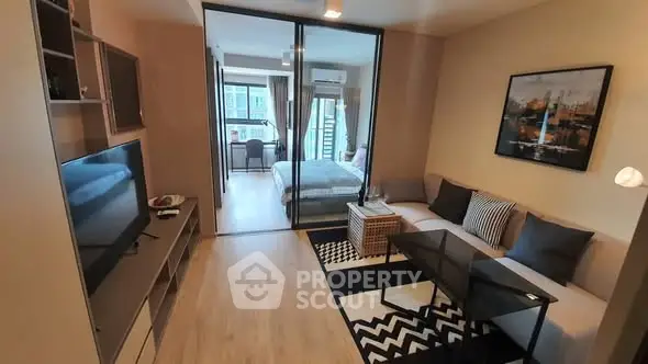 Modern apartment living room with stylish decor and view into cozy bedroom