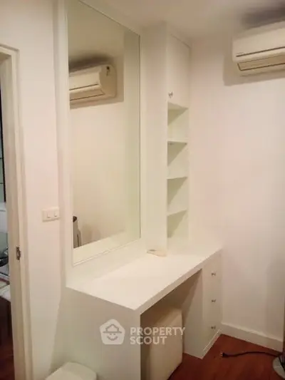 Modern bedroom with built-in vanity and air conditioning unit, perfect for comfort and style.