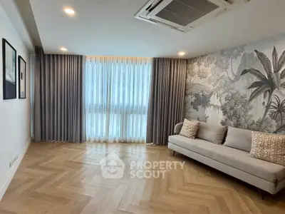 Spacious living room with elegant decor and large window, featuring a stylish sofa and artistic wall design.