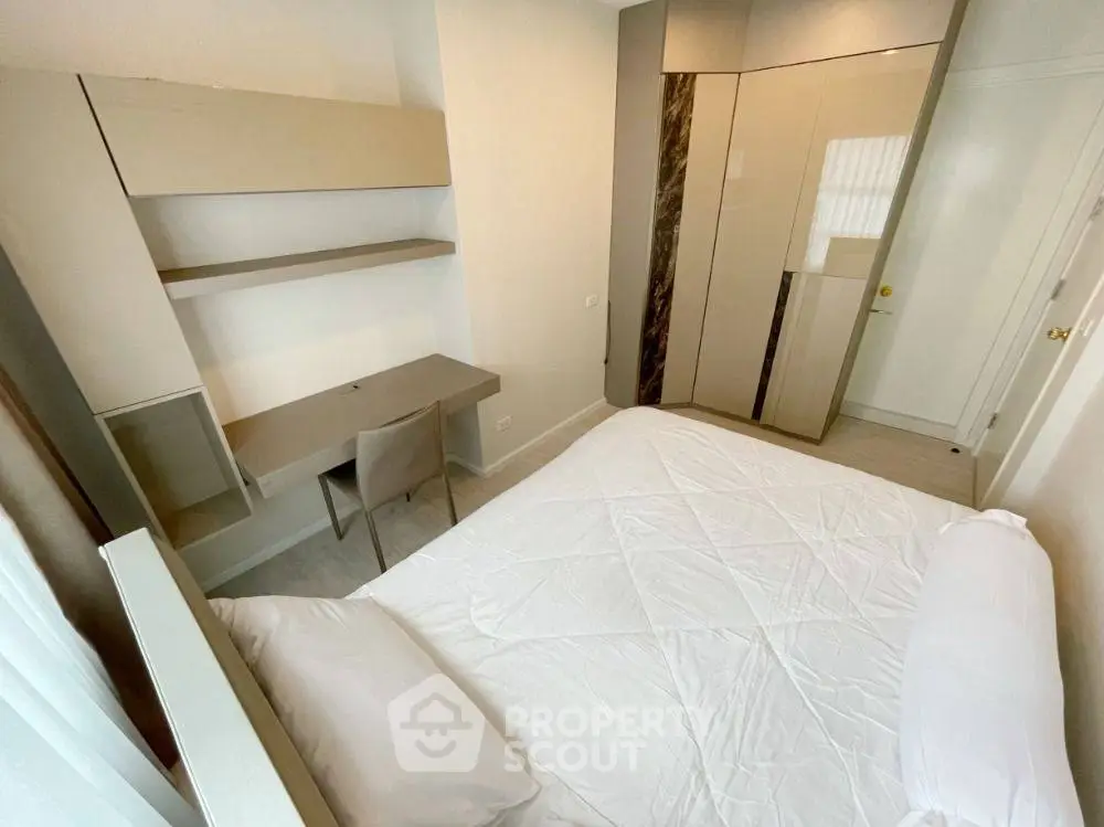 Modern bedroom with sleek design, built-in wardrobe, and cozy workspace