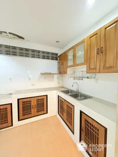 Spacious kitchen with wooden cabinets and double sink in modern home