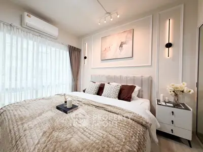 Luxurious bedroom with elegant decor and natural light, featuring a plush bed and stylish lighting.