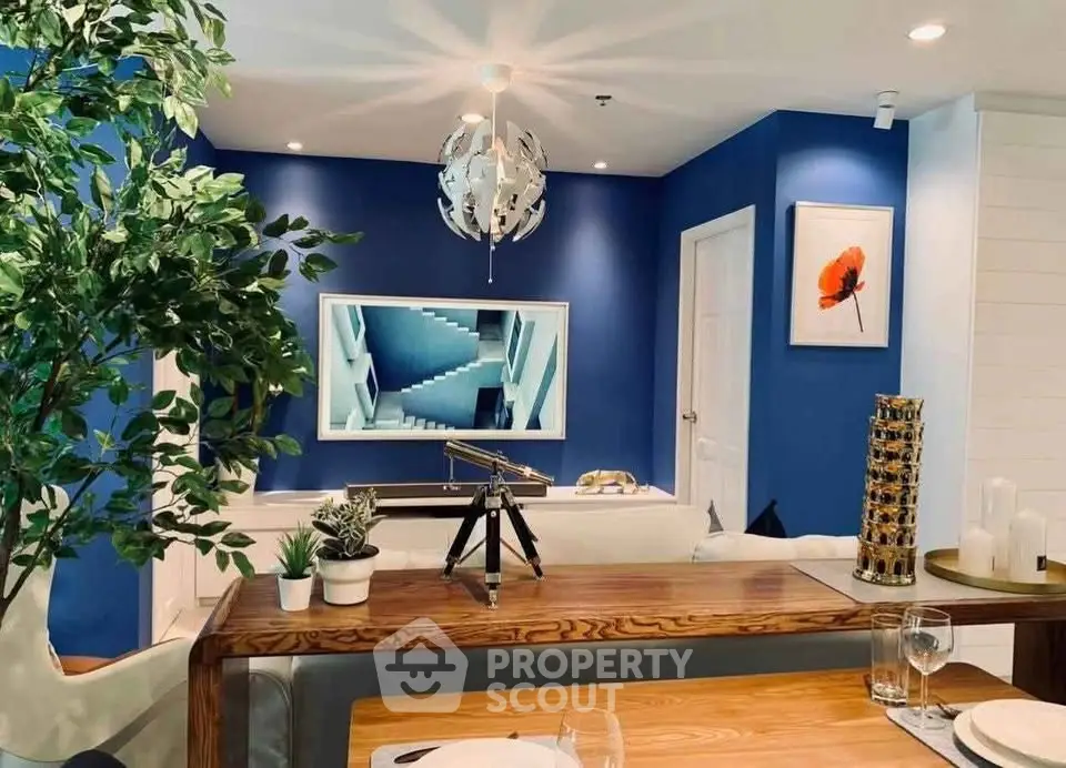 Stylish living room with modern decor, blue accent wall, and elegant dining setup.