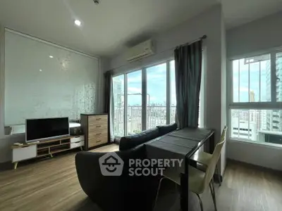 Modern living room with city view, featuring sleek furniture and large windows for natural light.