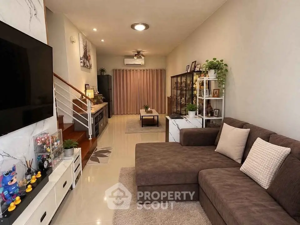 Stylish living room with modern decor, cozy sectional sofa, and elegant staircase in a contemporary home.