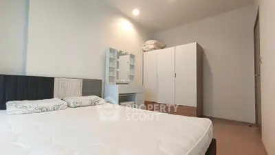 Spacious bedroom with modern furniture and ample storage space.