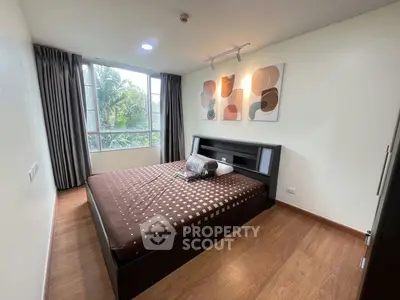 Modern bedroom with large window and stylish decor in a contemporary apartment.