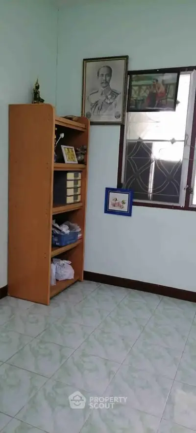 Cozy room with tiled floor and wooden shelving, ideal for storage or study space.