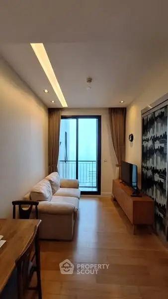 Cozy living room with modern furniture and balcony access in a stylish apartment.