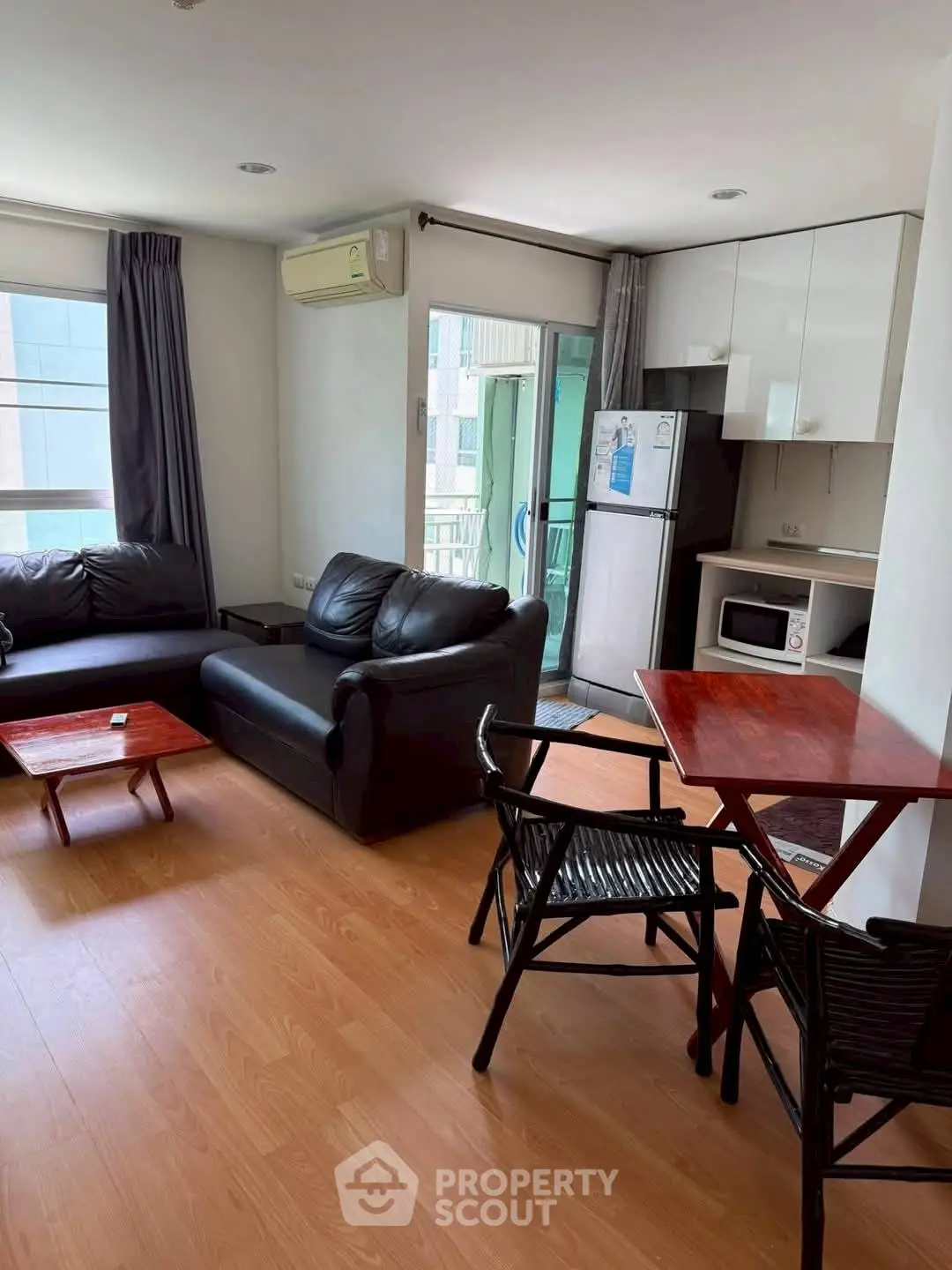 Cozy living room with modern furniture and balcony access in urban apartment.