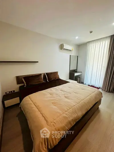 Modern bedroom with cozy bedding and natural light from large window