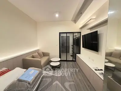 Modern studio apartment with sleek design and cozy furnishings, featuring a comfortable bed and stylish seating area.
