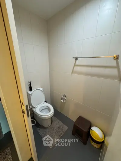 Modern bathroom with sleek tile design and essential amenities.