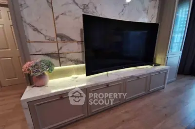 Elegant living room with modern TV setup and marble accents