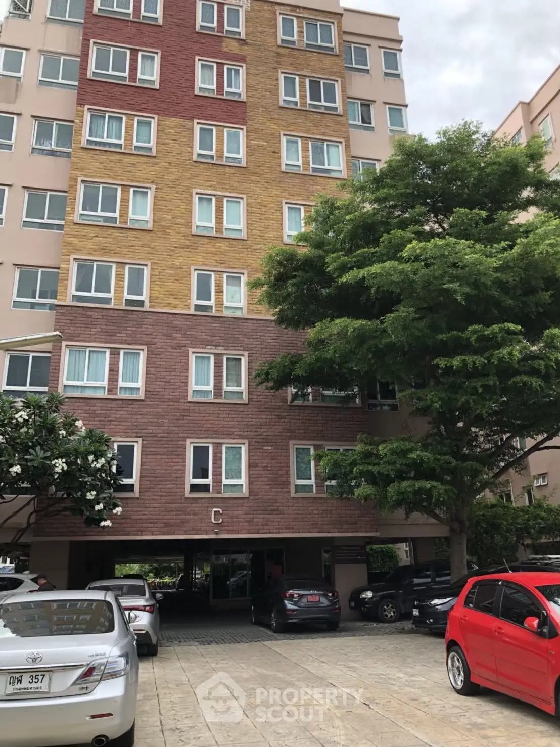 Modern apartment building exterior with colorful facade and parking area.