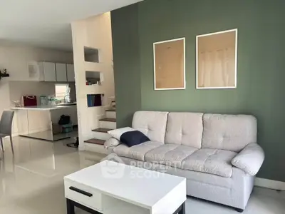 Modern living room with stylish sofa and open kitchen layout, perfect for contemporary living.