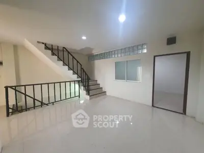 Spacious modern interior with sleek staircase and bright lighting