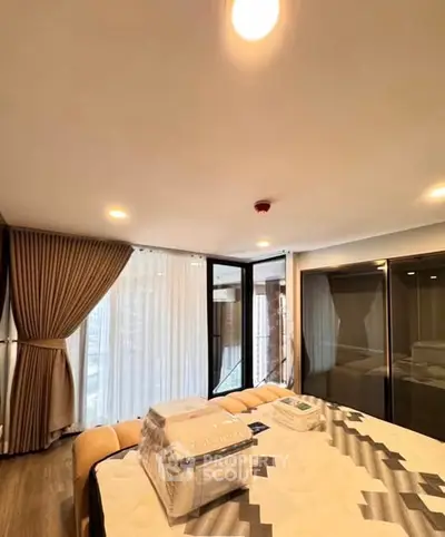 Spacious bedroom with large windows and modern decor in a luxury apartment.