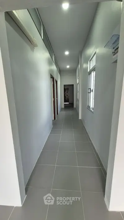 Spacious hallway with modern tile flooring and ample natural light