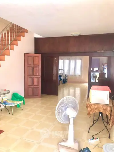 Spacious living room with open layout and staircase, ideal for family gatherings.