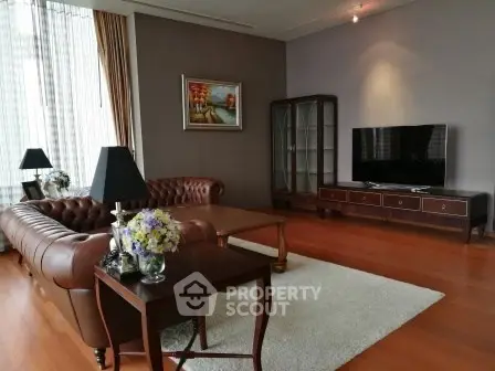 Elegant living room with leather sofas, wooden flooring, and a large TV, perfect for relaxation and entertainment.